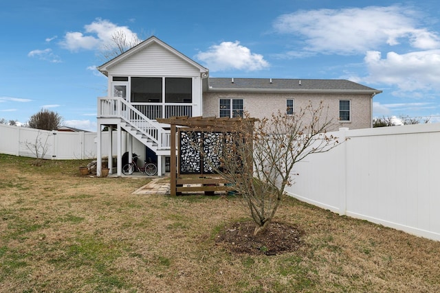 rear view of house with a yard and a sunroom