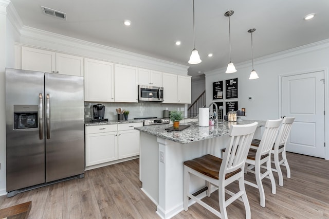 kitchen with stainless steel appliances, white cabinetry, visible vents, tasteful backsplash, and crown molding