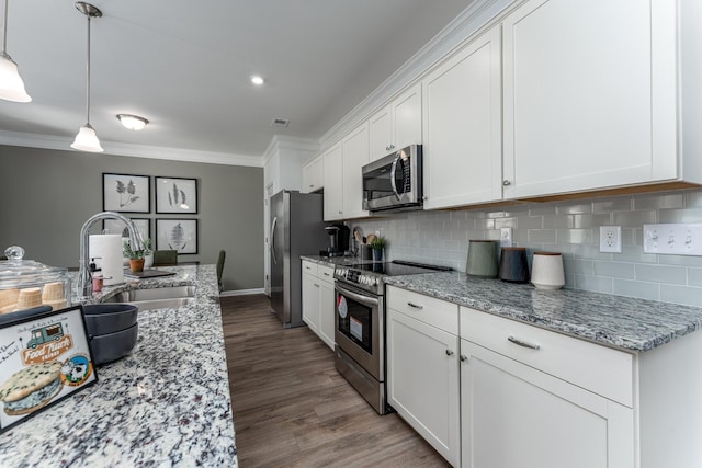 kitchen with white cabinetry, ornamental molding, stainless steel appliances, and a sink