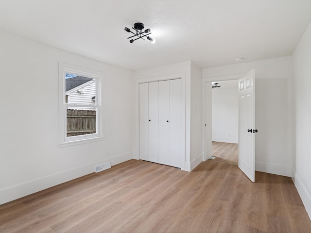 unfurnished bedroom featuring light wood-type flooring and a closet