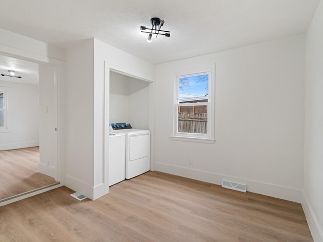 clothes washing area featuring independent washer and dryer and light wood-type flooring