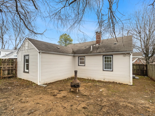 rear view of house featuring an outdoor fire pit