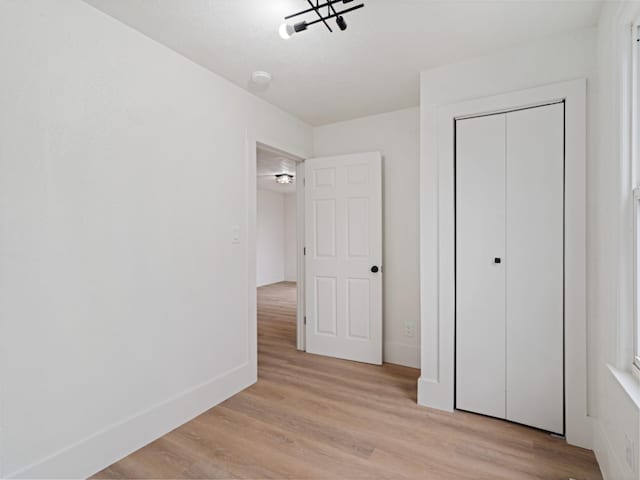 unfurnished bedroom with light hardwood / wood-style floors and a closet