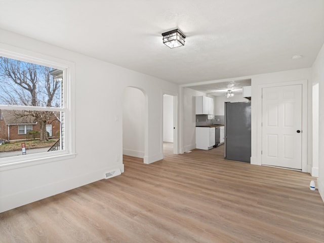 unfurnished living room with sink and light hardwood / wood-style flooring