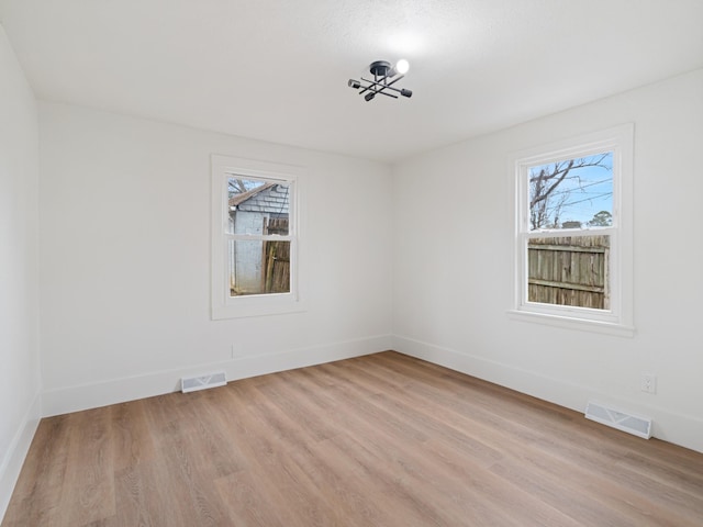 spare room with a healthy amount of sunlight and light hardwood / wood-style floors