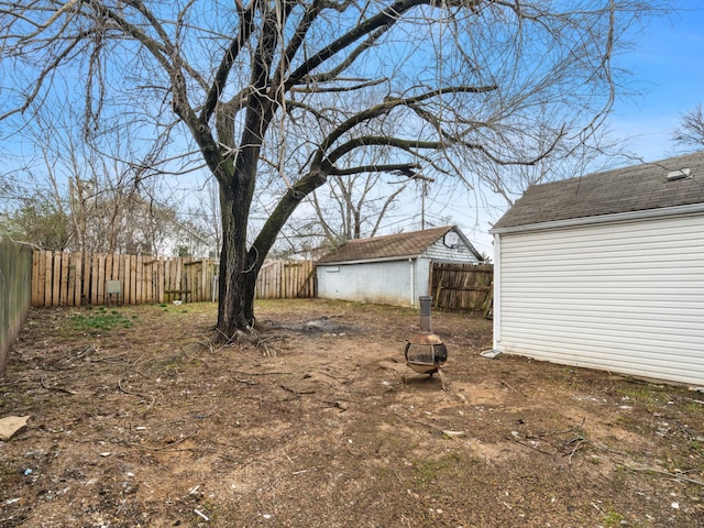 view of yard with a storage unit and a fire pit