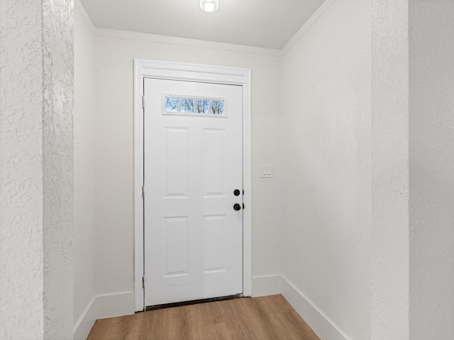 doorway featuring hardwood / wood-style flooring and ornamental molding