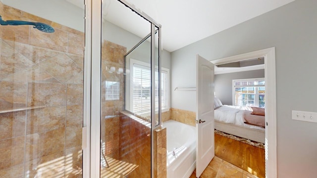 bathroom featuring plus walk in shower and plenty of natural light