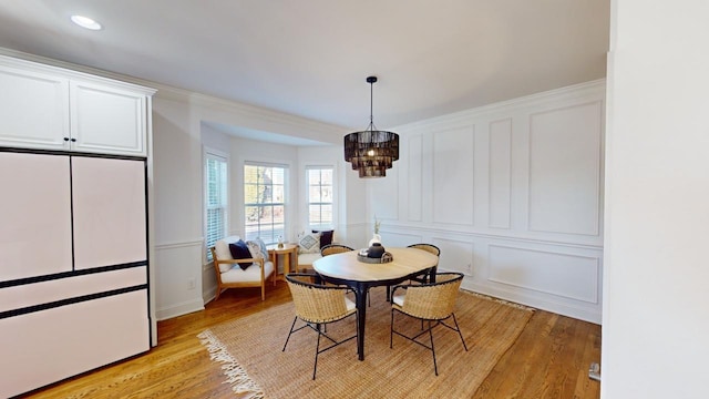 dining room with light hardwood / wood-style flooring and a chandelier