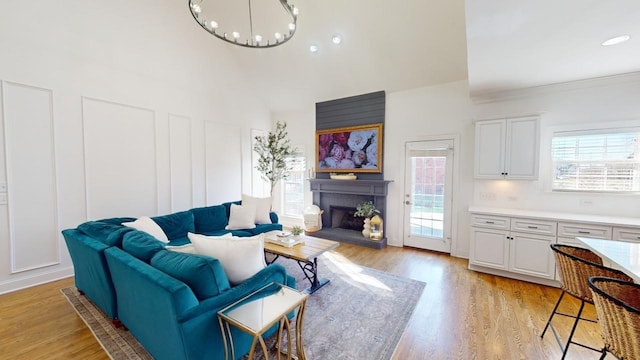 living room with light hardwood / wood-style floors, a chandelier, and crown molding