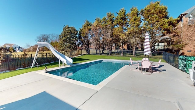 view of pool with a lawn, a patio, and a water slide