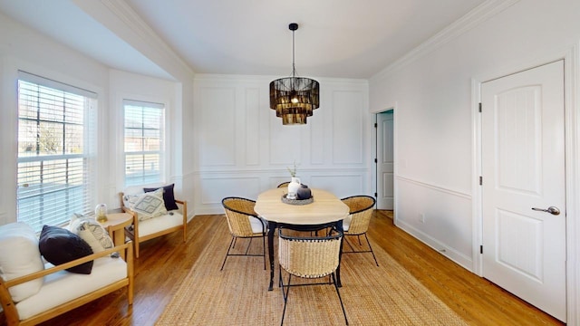 dining room featuring crown molding, a chandelier, and wood-type flooring