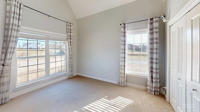 unfurnished room with light carpet and vaulted ceiling