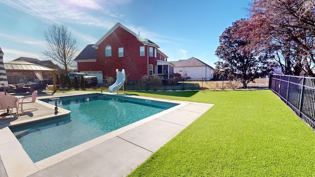 view of pool with a lawn, a water slide, and a gazebo