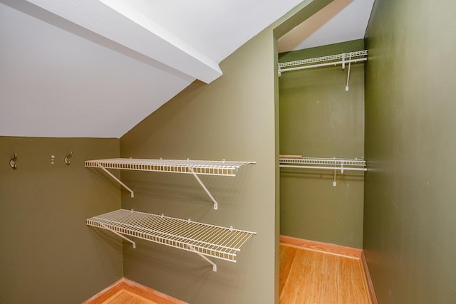 walk in closet featuring vaulted ceiling and wood-type flooring