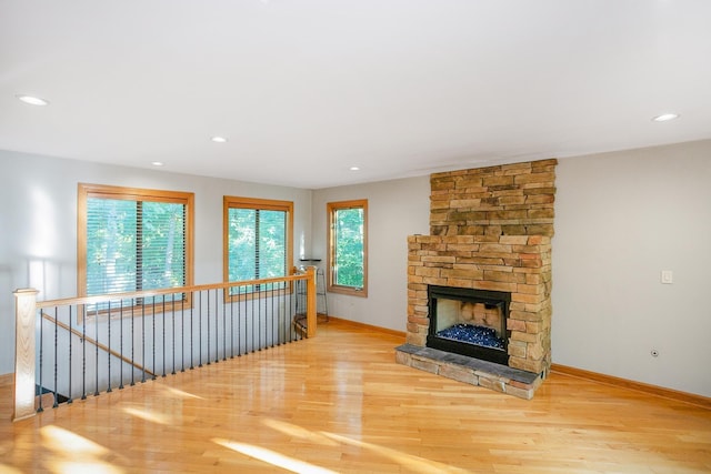 living room with hardwood / wood-style floors, a wealth of natural light, and a fireplace