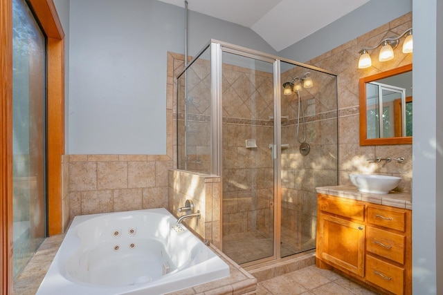 bathroom featuring tile walls, shower with separate bathtub, vaulted ceiling, tile patterned floors, and vanity