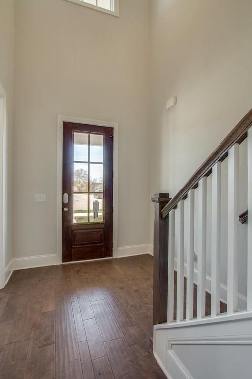 entryway with dark wood-type flooring and a high ceiling