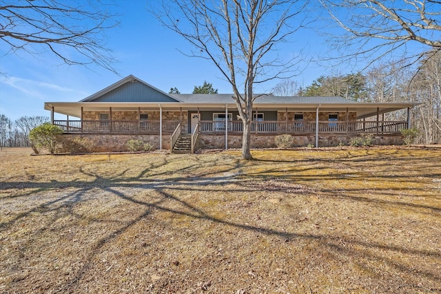 back of property with a lawn and a porch