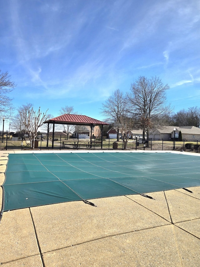 community pool with fence and a gazebo