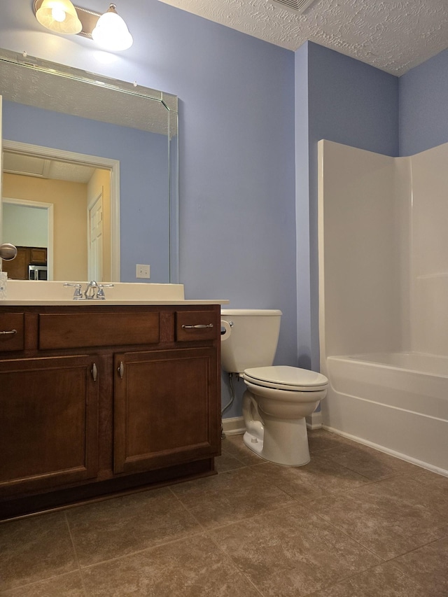 bathroom featuring toilet, tile patterned flooring, bathtub / shower combination, a textured ceiling, and vanity