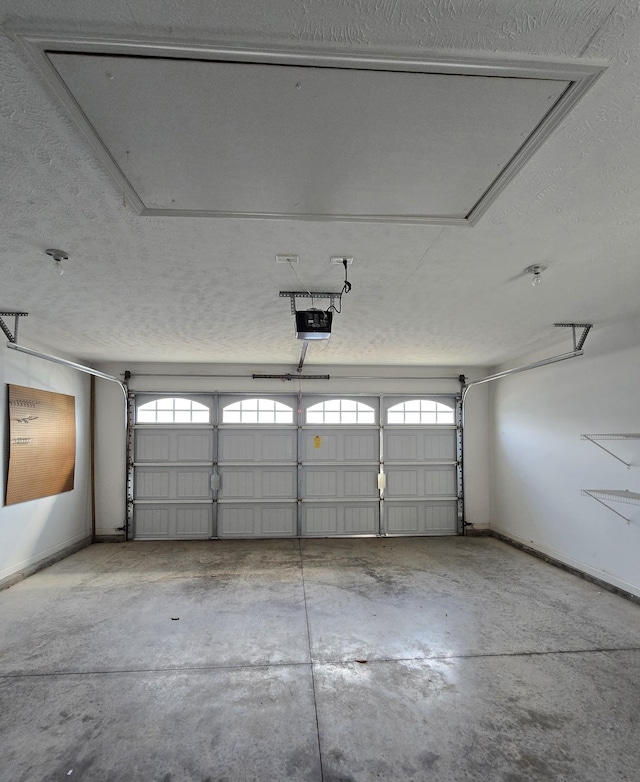 garage featuring a garage door opener and baseboards