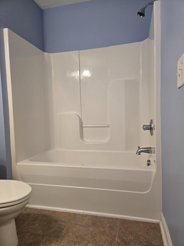 bathroom featuring a textured ceiling, shower / washtub combination, toilet, and baseboards