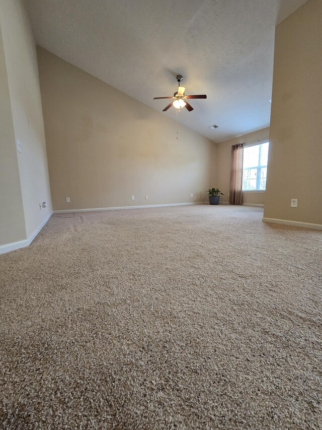 unfurnished room with ceiling fan, baseboards, vaulted ceiling, and a textured ceiling