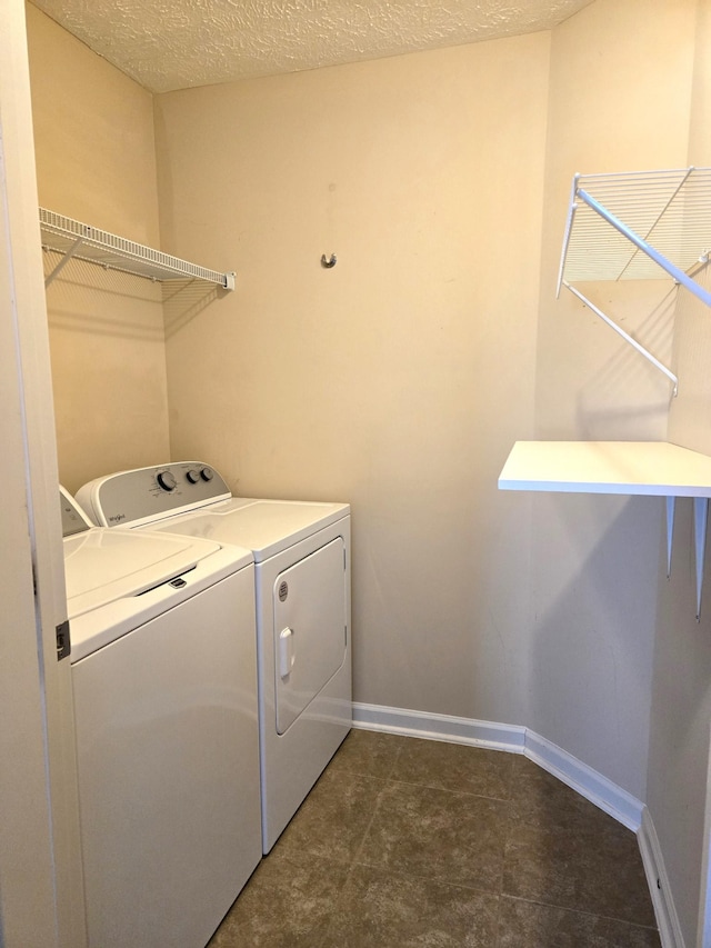 laundry area with washing machine and dryer, laundry area, a textured ceiling, and baseboards