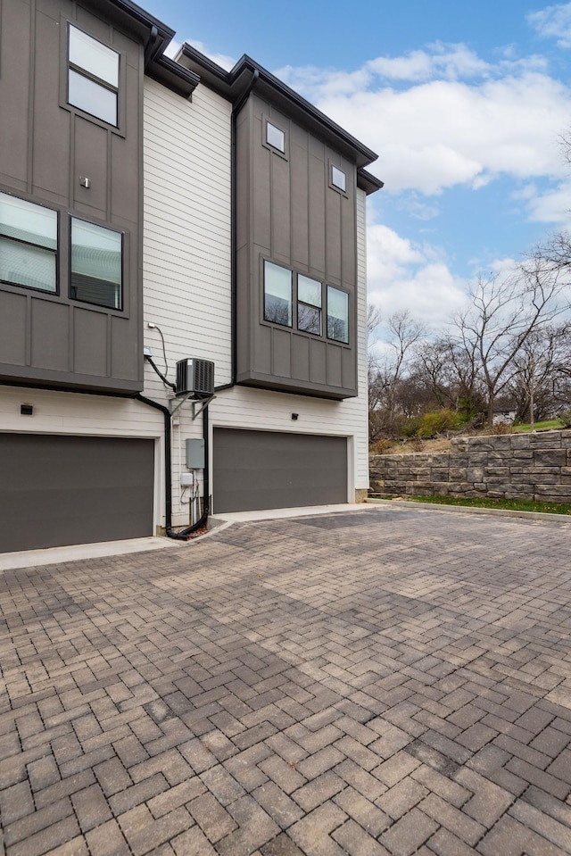 view of side of property featuring central AC unit and a garage