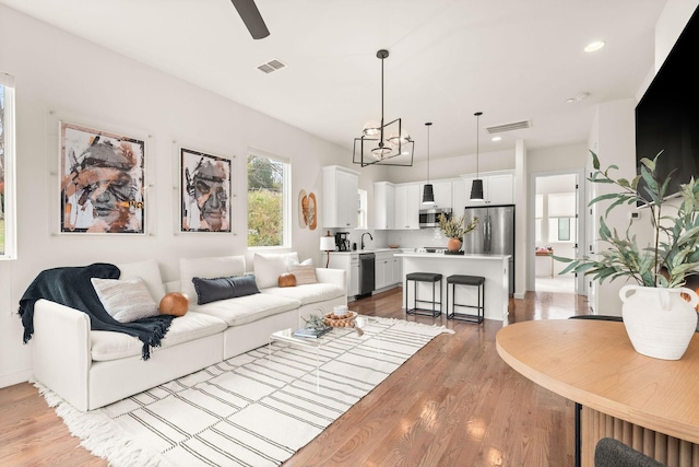 living room with ceiling fan and light hardwood / wood-style flooring