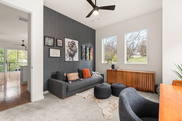 carpeted living room featuring radiator and ceiling fan