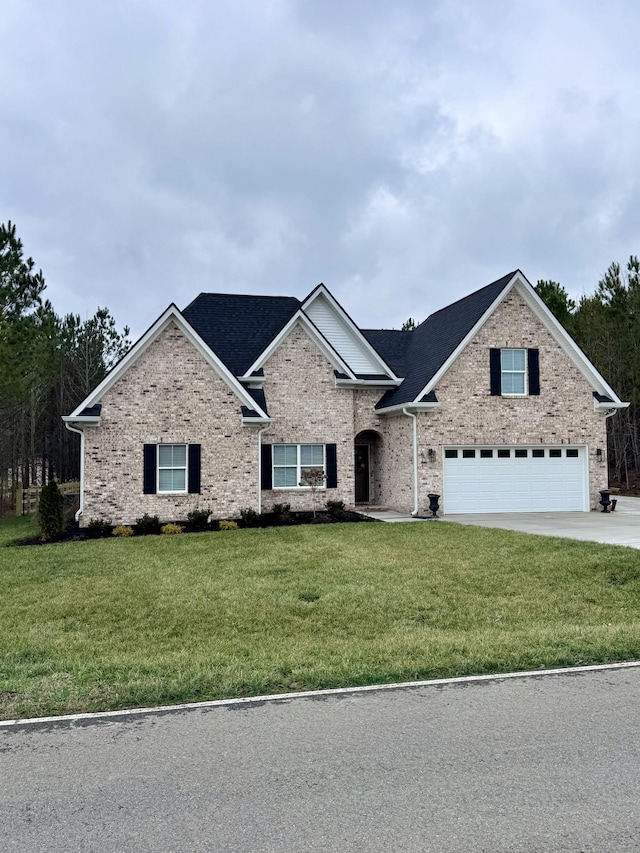 view of front of home featuring driveway, a front lawn, an attached garage, and brick siding