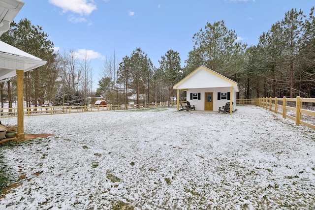 snowy yard featuring an outdoor structure and fence