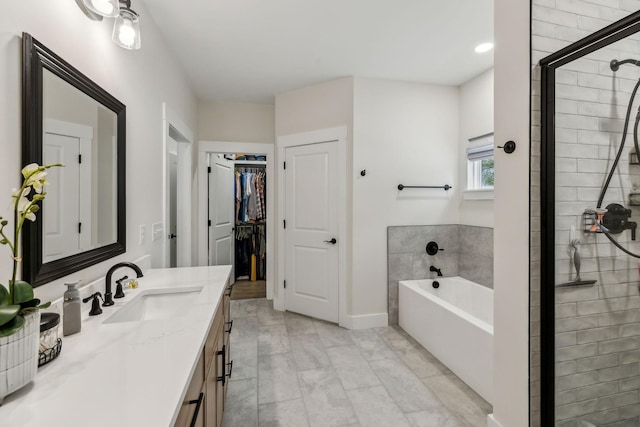 full bathroom with a shower stall, vanity, a bath, and a walk in closet