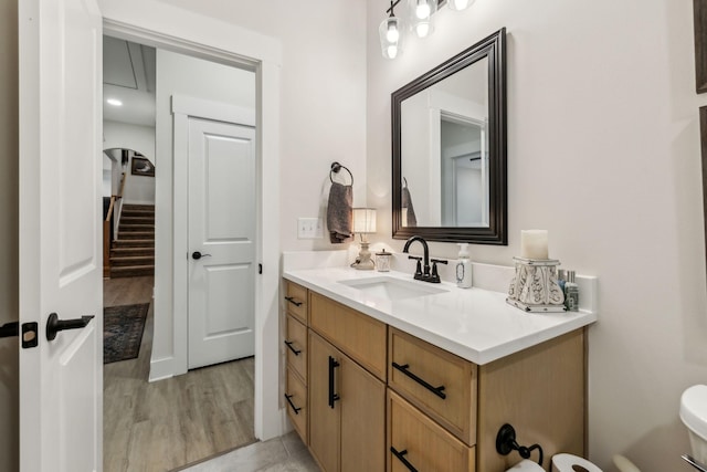 bathroom featuring toilet, wood finished floors, and vanity