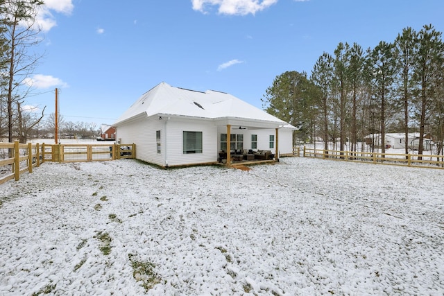 snow covered house with fence