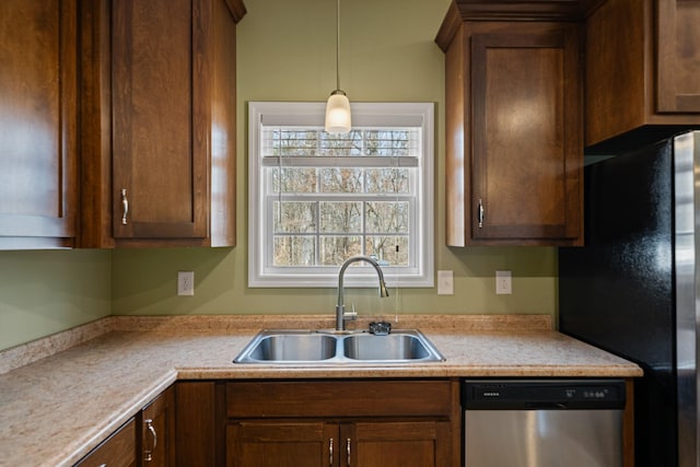 kitchen with stainless steel dishwasher, black refrigerator, sink, and decorative light fixtures