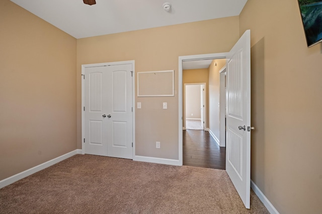 unfurnished bedroom with ceiling fan, carpet floors, and a closet