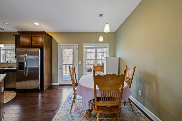 dining area with sink, dark hardwood / wood-style flooring, and plenty of natural light