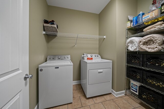 laundry room with light tile patterned floors and washer and clothes dryer