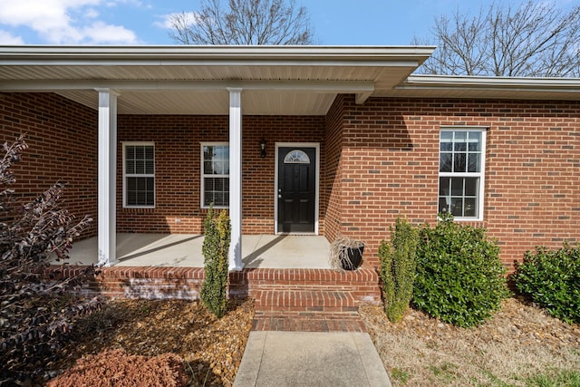 view of exterior entry featuring covered porch