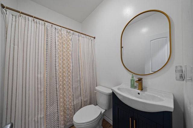 bathroom featuring toilet, vanity, and curtained shower