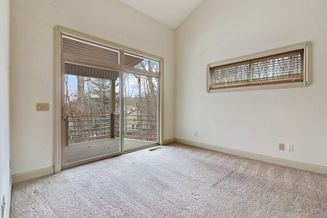 carpeted spare room with vaulted ceiling