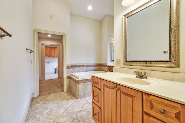 bathroom featuring tile patterned floors, tiled bath, and vanity