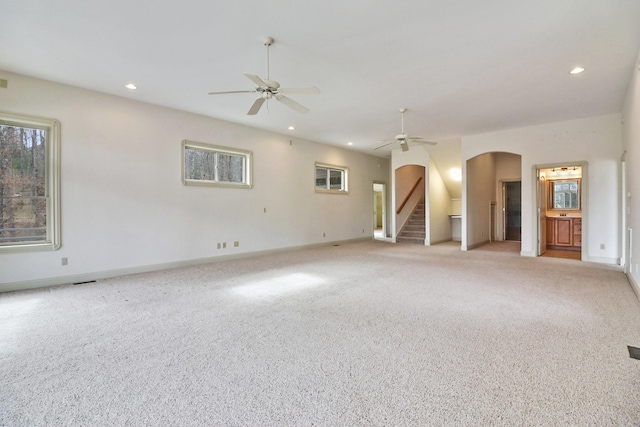 empty room featuring a wealth of natural light, ceiling fan, and light colored carpet