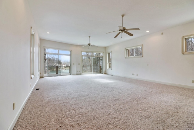 carpeted spare room featuring ceiling fan