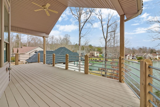 wooden terrace with a water view and ceiling fan