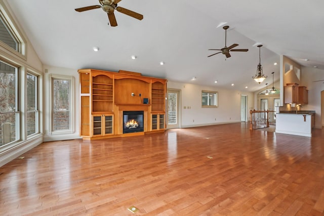 unfurnished living room featuring light wood-type flooring, high vaulted ceiling, and ceiling fan