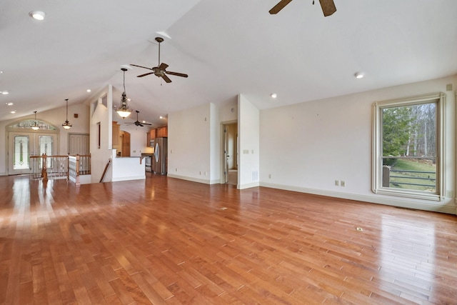 unfurnished living room featuring light wood-type flooring, vaulted ceiling, and ceiling fan